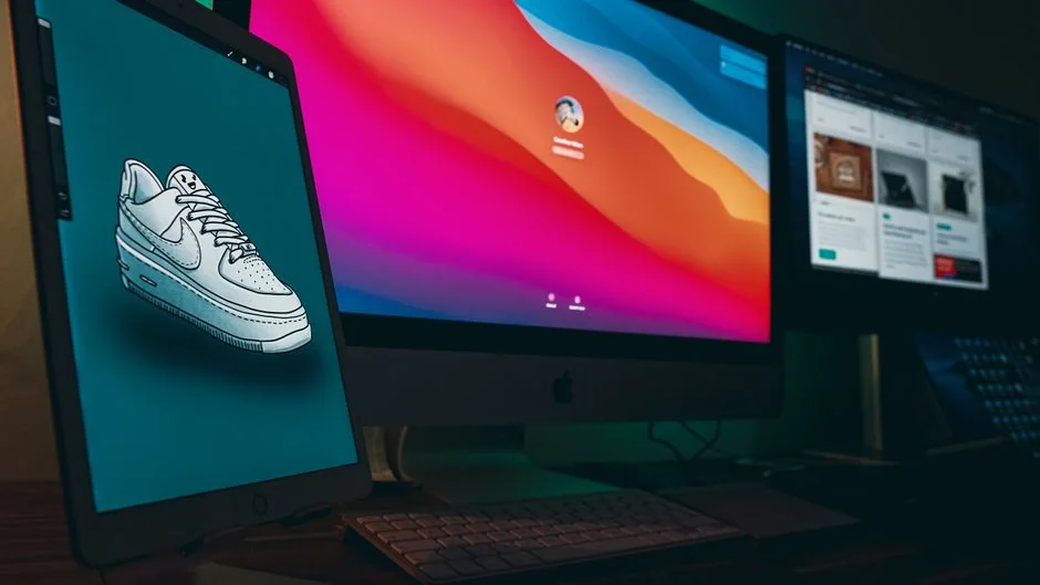 A bright desk setup featuring a design book, laptop, and creative tools, ideal for inspiration.